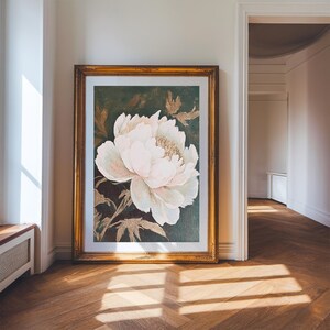 May include: A framed print of a large, white peony flower with gold accents on a dark green background.