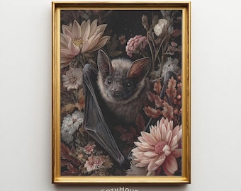 May include: A framed print featuring a bat amidst flowers in shades of pink, brown, and cream. The bat has large ears and dark wings. The print is in a gold frame, with the text "GOTH HOUSE printery" at the bottom.