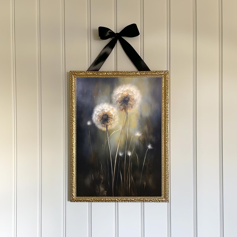 May include: A framed artwork featuring a painting of dandelions. The painting is in a gold ornate frame and is suspended by a black ribbon. The dandelions are white and fluffy against a dark background.