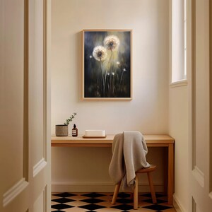 May include: A framed painting of two dandelions in a field, with a dark background and a wooden frame. The painting hangs above a wooden desk with a small chair and a patterned floor.