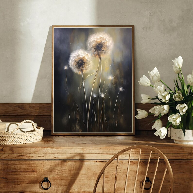 May include: A framed artwork featuring a close-up of dandelions. The painting showcases two large, fluffy dandelion seed heads with a soft, glowing light. The background is a dark, moody blend of greens and blues, with hints of yellow.
