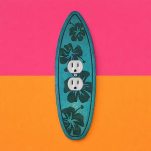 May include: A teal surfboard-shaped light switch cover with dark green hibiscus flower designs. The cover has two white electrical outlets. The background is divided into pink and orange sections.