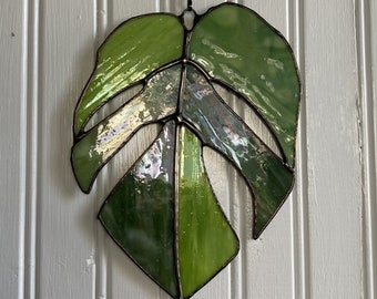 Stained glass Monstera leaf sun-catcher, mix of green colors, and textures to replicate the natural beauty of the plant.  6 x 8 inches.