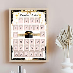 Può includere: Un calendario di Ramadan stampabile con una cornice nera e dettagli dorati. Il calendario presenta uno sfondo rosa con quadrati bianchi numerati da 1 a 30. Il calendario include anche una rappresentazione della Kaaba, un edificio a forma di cubo a La Mecca, in Arabia Saudita, considerato il luogo più sacro dell'Islam.
