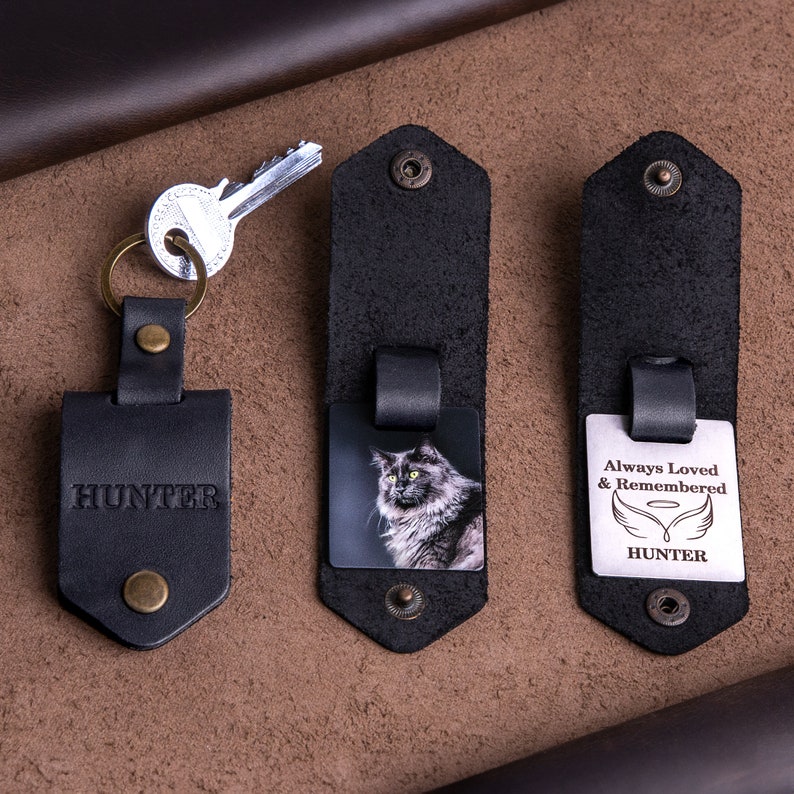 May include: Black leather keychains with metal accents. One keychain has the name "HUNTER" embossed. Another features a photo of a cat, and the third has the text "Always Loved & Remembered" with angel wings and the name "HUNTER".
