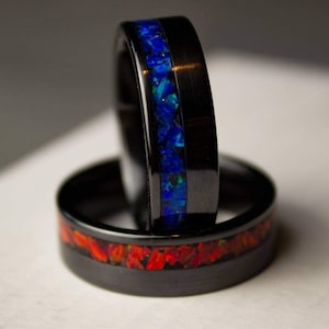 May include: Two black tungsten carbide rings with a blue and red inlay. The rings are stacked on top of each other.