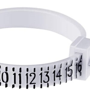 Op de afbeelding: Een witte plastic ringmaat met zwarte cijfers van 6 tot 16. De ringmaat heeft een wit plastic lipje met de tekst "PAT. PEND. 9101693".