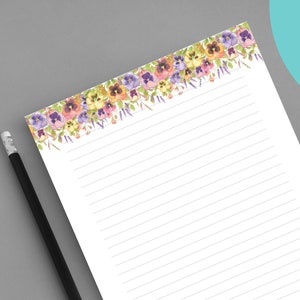 Op de afbeelding: Printbaar, gestreept briefpapier met een rand van aquarelviooltjes in tinten paars, geel en roze. Het papier is 8,5 inch bij 11 inch of 8,5 inch bij 5,5 inch.