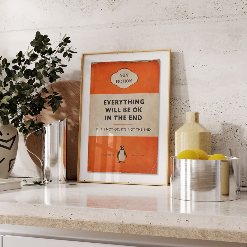 Peut inclure: Une impression encadr&eacute;e avec un fond rouge et un cadre dor&eacute;. L'impression pr&eacute;sente une couverture de livre avec le titre "Tout ira bien &agrave; la fin" et le texte "Si ce n'est pas bien, ce n'est pas la fin". La couverture du livre pr&eacute;sente &eacute;galement une illustration de pingouin.