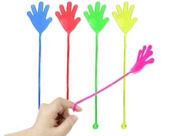 Puede incluir: Cinco juguetes de mano de plástico de colores en palos. Las manos son azules, rojas, verdes, amarillas y rosas. Los palos son todos de la misma longitud y tienen un pequeño bucle en la parte inferior.