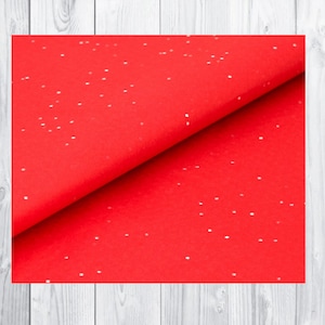 May include: Red tissue paper with white polka dots. The paper is folded in half, showing the texture of the paper.