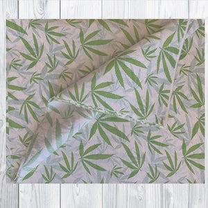 May include: White tissue paper with a repeating pattern of green cannabis leaves.