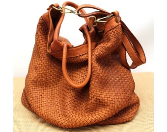 Könnte beinhalten: Eine braune, gewebte Ledertasche mit zwei Henkeln oben und einem langen Schulterriemen.