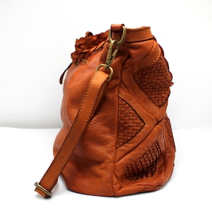 May include: A brown leather handbag with a braided strap and woven details.