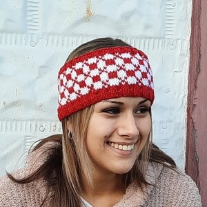 May include: A red and white checkered knit headband. The headband is worn by a person with long brown hair and a pink sweater.