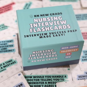May include: A teal blue box of nursing interview flashcards for new graduates. The box has the text "RN New Grads Nursing Interview Flashcards Interview Success Prep Made Easy!" and lists the specialties: Med-Surg, Telemetry, ER, and ICU.