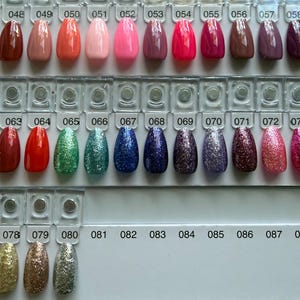 Pu&ograve; includere: Una cartella colori per smalti con file di punte per unghie ovali in varie finiture, tra cui texture crema solide, neon e glitterate. Ogni punta &egrave; numerata da 046 a 090, mostrando un ampio spettro di colori.