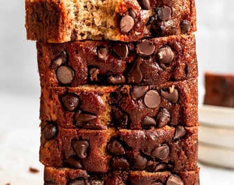 May include: A stack of six slices of banana bread with chocolate chips. The bread is a light brown color and the chocolate chips are dark brown.
