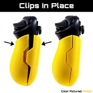 May include: Two black and yellow game controller grips. The grips are amber-colored and feature a textured surface. The text "Clips In Place" is at the top of the image. The text "Color Pictured: Amber" is at the bottom of the image.
