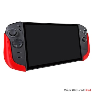 May include: A handheld gaming console with a black screen and red accents. The console features a black body with red grips on each side. It has a directional pad, buttons, and joysticks for gameplay. The text "Color Pictured: Red" is at the bottom.