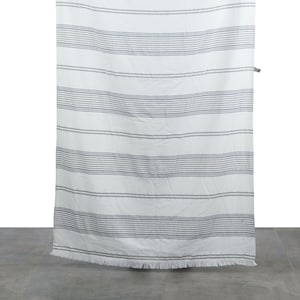 May include: White beach towel with blue and grey stripes. The towel has a fringed edge.