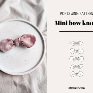 May include: A PDF sewing pattern for making mini bow knots. The pattern includes five different bow knot designs. The image shows a pink fabric bow knot.
