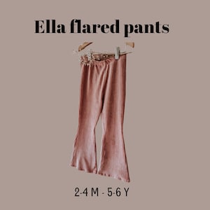 May include: Pink ribbed flared pants hanging on a wooden hanger. The pants have a wide leg and are made of a soft, textured fabric. The text "Ella flared pants" is at the top, and "2-4 M - 5-6 Y" is at the bottom.