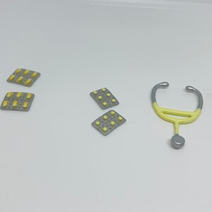 May include: Four silver and yellow pill packs and a yellow and silver toy stethoscope.
