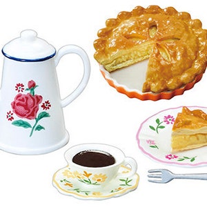 May include: A white teapot with a floral design, a cup of coffee, a fork, and two plates of apple pie. The pie is in a fluted orange dish and the other plate has a pink floral design.