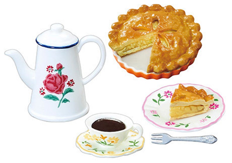 May include: A white teapot with a floral design, a cup of coffee, a fork, and two plates of apple pie. The pie is in a fluted orange dish and the other plate has a pink floral design.