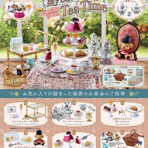 以下が含まれることがあります： ピンクと白のカラーリングで、6つのミニチュアティーパーティーアイテムのセット。セットには、銀のティーポット、ティーカップとソーサー、ピンクのケーキが載った3段のケーキスタンド、銀のシュガーボウル、銀のクリーマー、赤いコートを着たミニチュアのテディベアが含まれています。このセットは、「My Secret Tea Time」というコレクションの一部です。