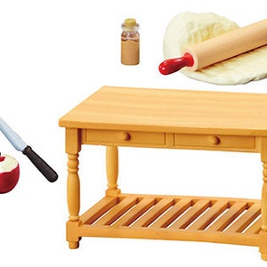 May include: A miniature wooden kitchen table with two drawers and a bottom shelf. There is a rolling pin and dough, a knife and a peeled apple, and a small glass jar with a cork lid.