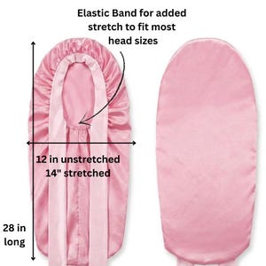 May include: A pink satin bonnet with an elastic band for added stretch. The bonnet is 71 cm long and 30 cm unstretched, stretching to 36 cm. The text says "Elastic Band for added stretch to fit most head sizes."