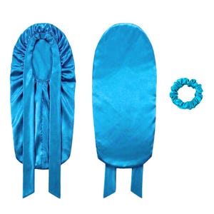 May include: A set of three turquoise satin hair accessories. The set includes a bonnet with long ties, a long satin hair wrap, and a scrunchie. The items are displayed on a white background.