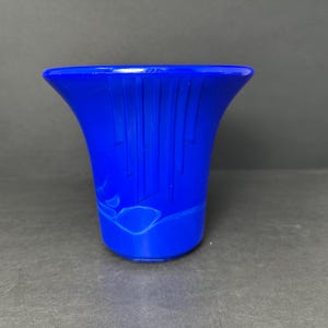 Puede incluir: Un jarrón de vidrio azul cobalto con un diseño acanalado y un patrón geométrico.