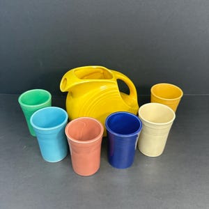 Vintage Fiestaware Juice Set with Yellow Pitcher and Six Model 1090 Juice Tumblers in Assorted Colors – Authentic 1939–1943 Fiesta Pottery