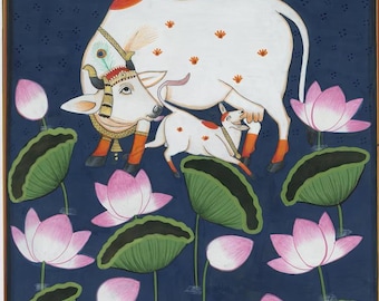 Può includere: Dipinto in miniatura indiano raffigurante una mucca bianca e il suo vitello con elementi decorativi. La mucca è adornata da una corona e il vitello sta allattando. Fiori di loto rosa e foglie di ninfea verdi in primo piano su sfondo blu scuro.