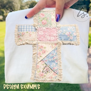 May include: A white fabric with a cross design. The cross is made of patchwork squares in pastel colors, including pink, blue, and cream, with floral patterns and lace details. The edges of the cross have a fringed trim. Text at the bottom reads "DESIGN EXAMPLE".