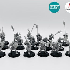 Puede incluir: Colección de figuras en miniatura grises que representan una escena de batalla medieval. Las figuras están montadas sobre bases negras. Algunas figuras sostienen lanzas, otras escudos. Incluye los logotipos de "MIM Printworks" y "Medway Miniatures".