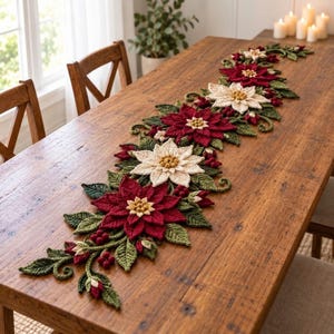 Puede incluir: Un camino de mesa decorativo y alargado con un diseño floral de ganchillo que incluye flores de pascua en rojo oscuro y crema, hojas verdes y pequeñas bayas rojas. Esta pieza textil detallada se extiende sobre una mesa de madera.