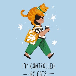 May include: A woman with a cat on her head walks with a coffee cup and a yellow tote bag. The text "I'm controlled by cats" is below her.