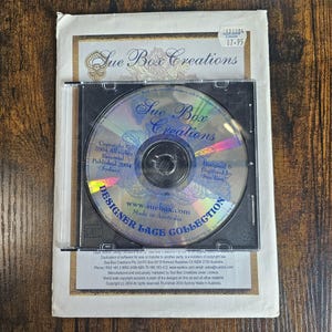 May include: A CD in a plastic case with a blue and white label that says "Sue Box Creations Designer Lace Collection". The CD is labeled with the text "Copyright 2004 All Rights Reserved. Published 2004 Sydney. www.suebox.com Made in Australia. Designed & Digitized by Sue Box."