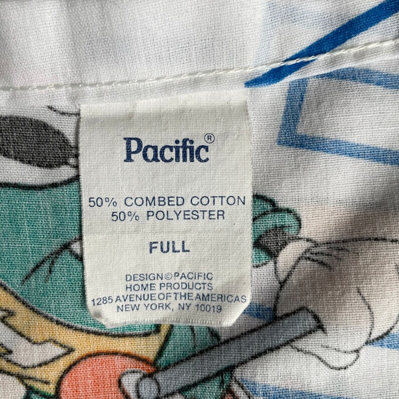 K&ouml;nnte beinhalten: Ein wei&szlig;es Etikett mit schwarzem Text, der "Pacific" in einer stilisierten Schriftart lautet. Das Etikett enth&auml;lt auch den Text "50% gek&auml;mmte Baumwolle 50% Polyester Full Design Pacific Home Products 1285 Avenue of the Americas New York, NY 10019".