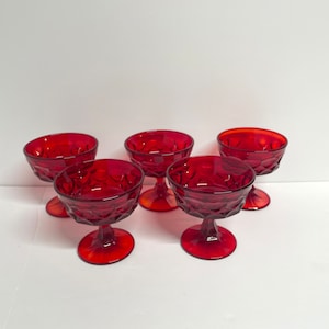 Può includere: Set di cinque coppette per dessert in vetro rosso con motivo a diamante. Le coppette hanno un gambo.