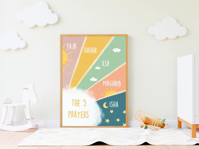 May include: A colourful illustration of the 5 daily prayers in Islam. The illustration features a rainbow with a sun and moon, clouds, and stars. The text "The 5 Prayers" is written in a white circle with a yellow outline. The names of the prayers are written in a yellow font on the rainbow: Fajr, Dhuhr, Asr, Maghrib, and Isha.