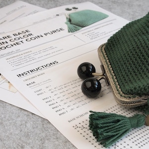 May include: A crochet pattern for a square base coin purse with instructions for crocheting the base in rounds. The pattern includes a base scheme with stitches marked in a grid. The image also shows a finished green coin purse with a metal clasp and a green tassel.