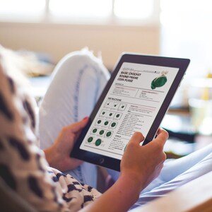 K&ouml;nnte beinhalten: Ein digitales Tablet zeigt ein H&auml;kelmuster f&uuml;r eine einfache runde Rahmen-M&uuml;nzb&ouml;rse. Das Muster enth&auml;lt Anweisungen und Diagramme zum H&auml;keln der B&ouml;rse.