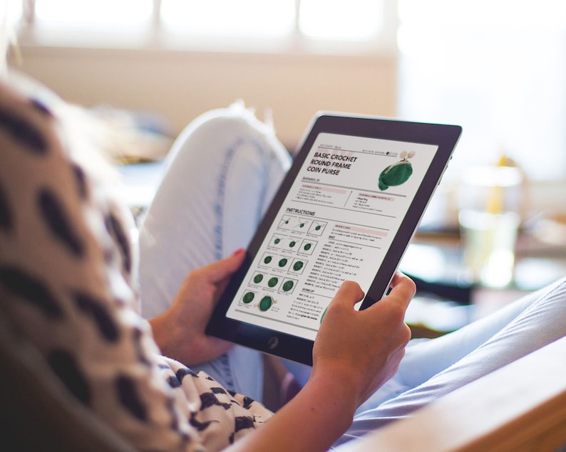 K&ouml;nnte beinhalten: Ein digitales Tablet zeigt ein H&auml;kelmuster f&uuml;r eine einfache runde Rahmen-M&uuml;nzb&ouml;rse. Das Muster enth&auml;lt Anweisungen und Diagramme zum H&auml;keln der B&ouml;rse.