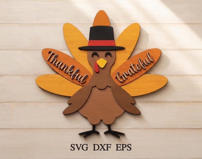 May include: A layered wooden turkey cutout featuring a black hat with a red band, a yellow beak, and a red wattle. The turkey has orange and yellow tail feathers with the words Thankful and Grateful in script. Text at the bottom reads SVG DXF EPS.