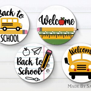 May include: Four round, white, paper, back to school themed, circle stickers. The stickers feature a yellow school bus, pencils, a ruler, an apple, a paper airplane, and the words "Back to School" and "Welcome".